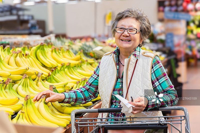 年长的女人在杂货店精心挑选农产品图片素材
