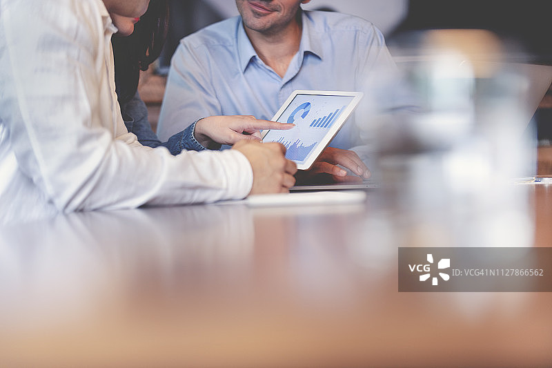 商务人士在数字平板电脑上处理财务数据图片素材