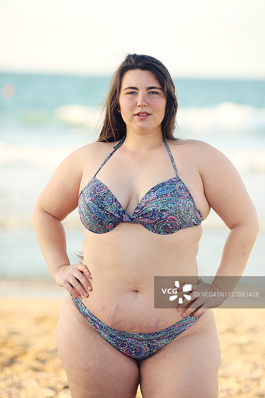 在海滩上穿着比基尼的加大码女性图片素材