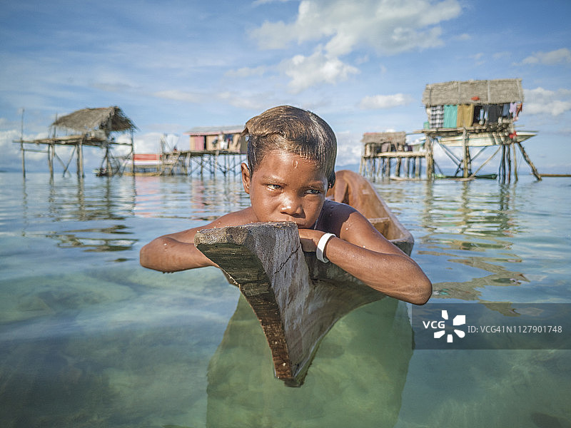 传统独木舟上不快乐的海上吉普赛男孩的面孔图片素材
