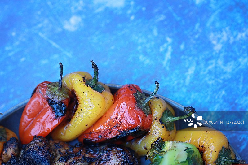 蓝色背景上的烤辣椒特写图片素材
