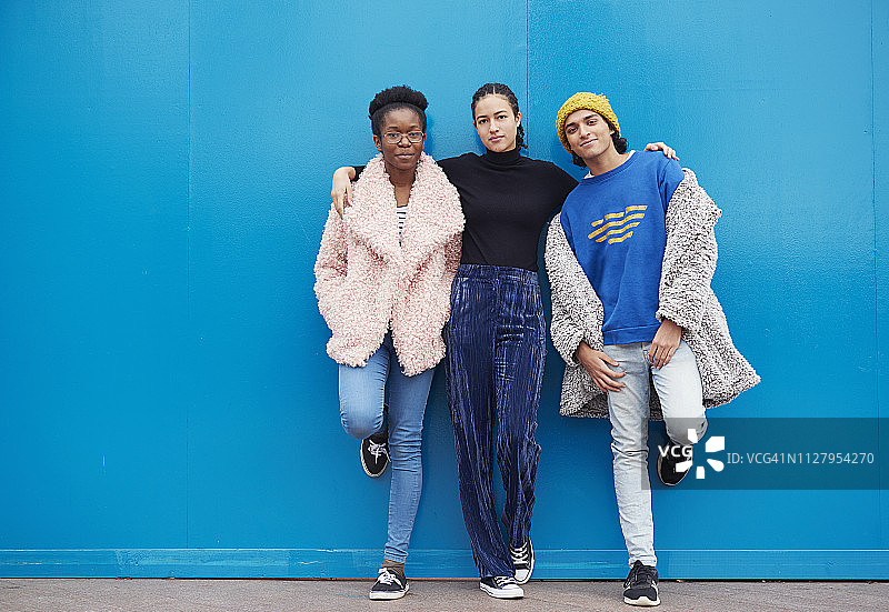 蓝色背景下的三个朋友的肖像图片素材