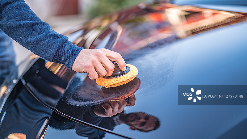 中年男人用涂抹垫擦拭汽车图片素材