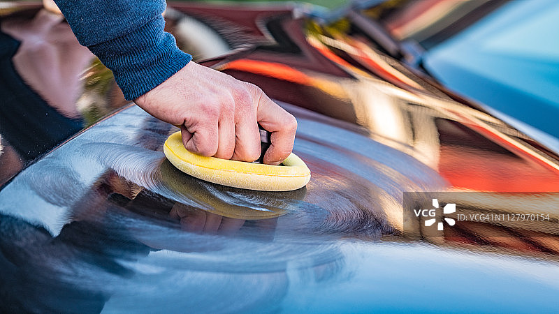 中年男人用涂抹垫擦拭汽车图片素材