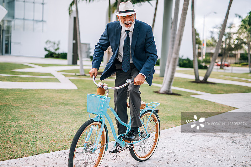 在美国穿着西装衬衫骑自行车的年长拉丁裔男人图片素材