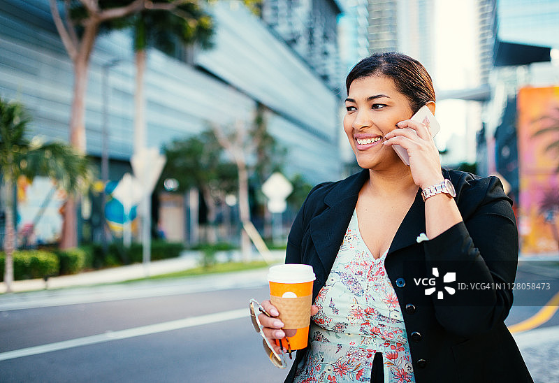 年长的拉丁裔女商人在美国金融区使用智能手机图片素材