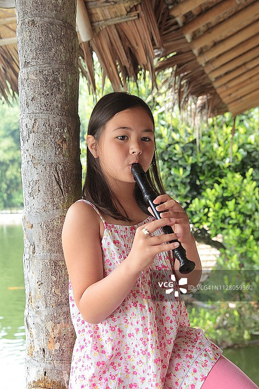 在户外吹竖笛的女孩图片素材