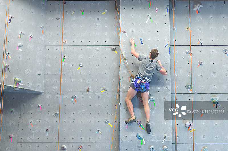 大学生攀爬室内攀岩墙图片素材