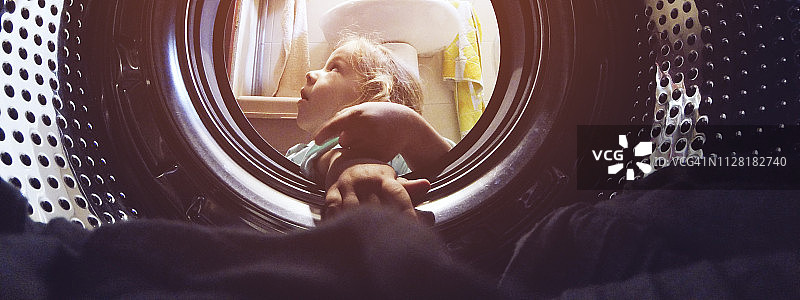 小女孩看着洗衣机图片素材