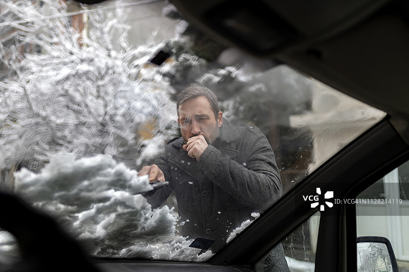 男人清除汽车上的积雪图片素材