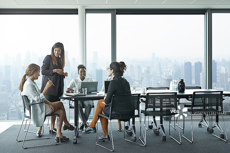 在会议室里开会，享有迷人天际线景色的商务女性图片素材