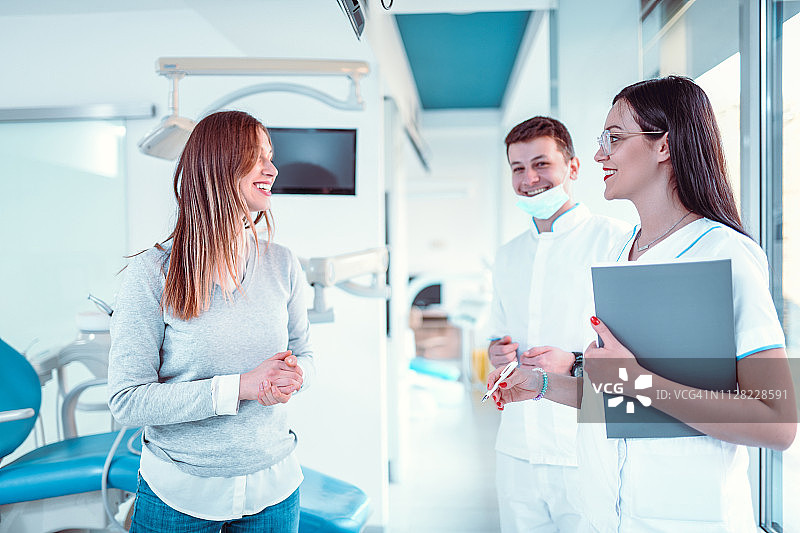牙医和护士向诊所患者讲解牙科手术过程图片素材