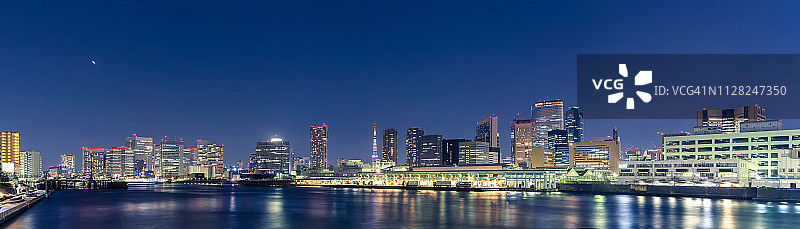 东京筑地市场、东京塔、摩天大楼和写字楼在隅田川上的东京城市夜景全景图片素材
