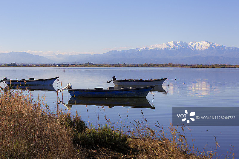 积雪山脉平静湖水渔船倒影图片素材