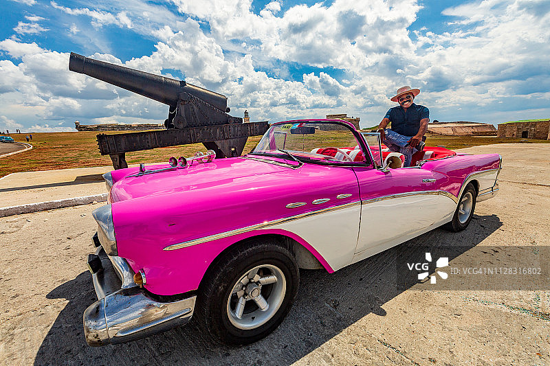 驾驶复古粉白汽车的出租车司机图片素材