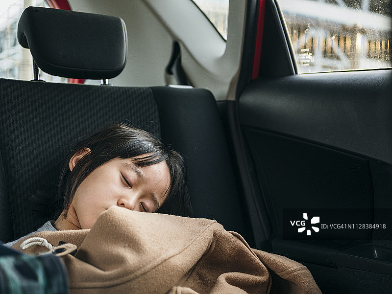可爱日本女孩在汽车后座睡觉图片素材