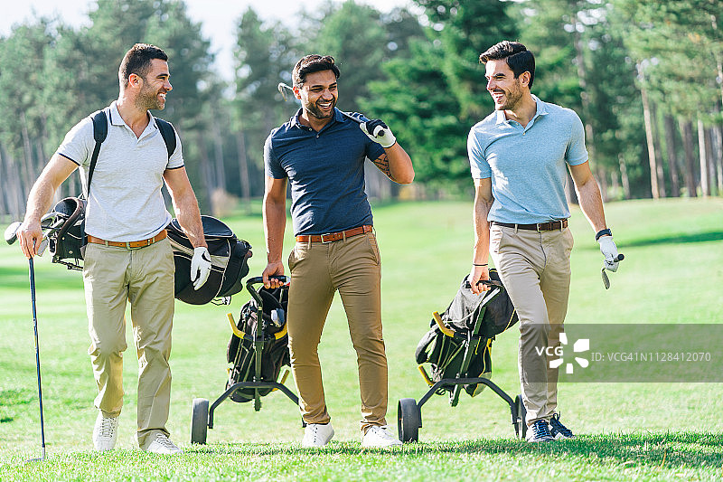 朋友们在阳光明媚的日子里打高尔夫图片素材