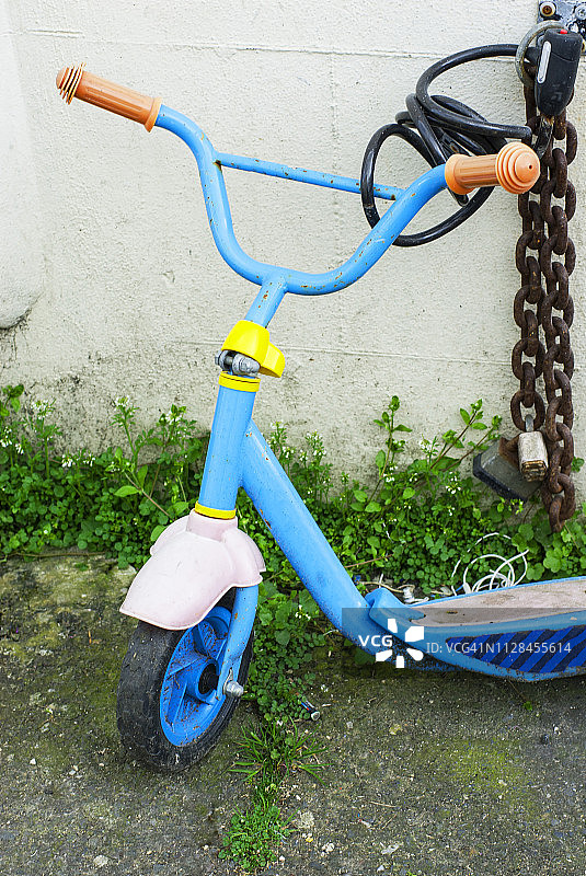 儿童滑板车用链条锁在墙上图片素材