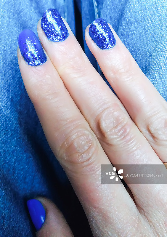 涂蓝色指甲油的女人手部特写图片素材