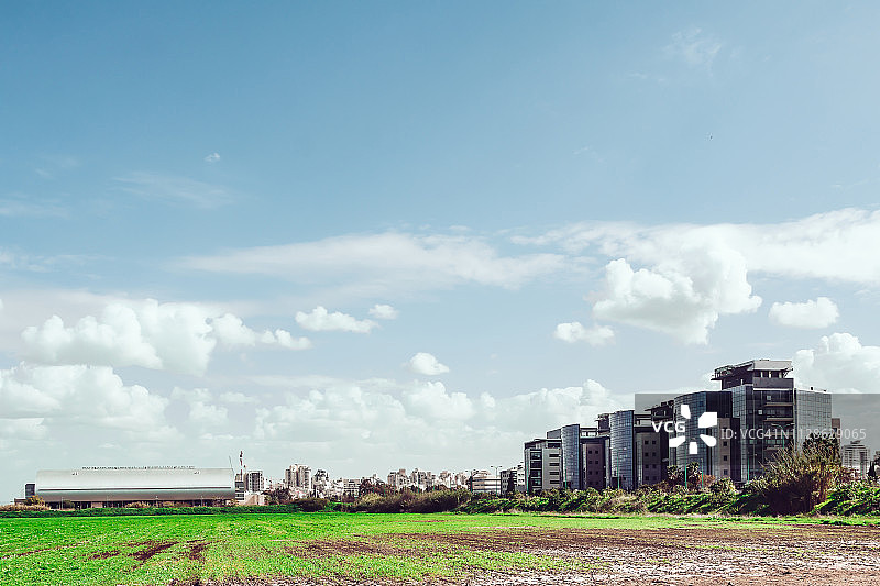 远眺城市景观的绿色田野图片素材