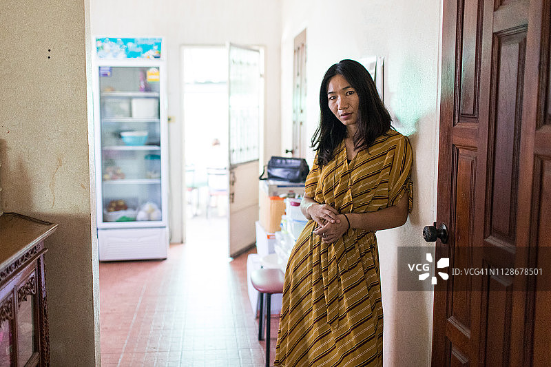穿着黄色连衣裙的阿卡族/泰国妇女居家肖像图片素材