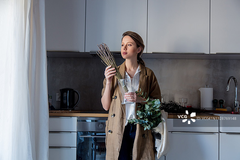女孩手捧薰衣草花束和一个布袋图片素材