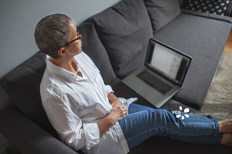 在沙发上使用笔记本电脑的女人图片素材