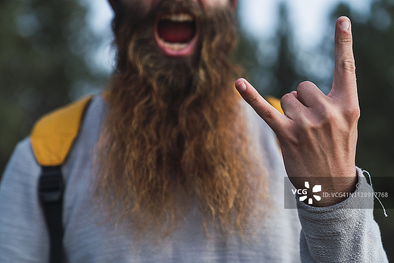 特写：蓄胡须的男子做摇滚手势图片素材