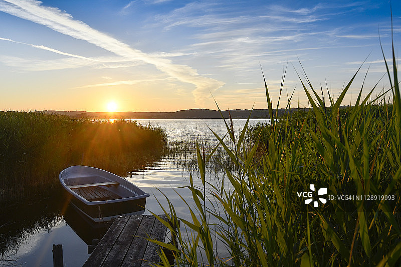 德国梅克伦堡-前波美拉尼亚吕根岛塞尔林日落时码头附近的空划艇图片素材