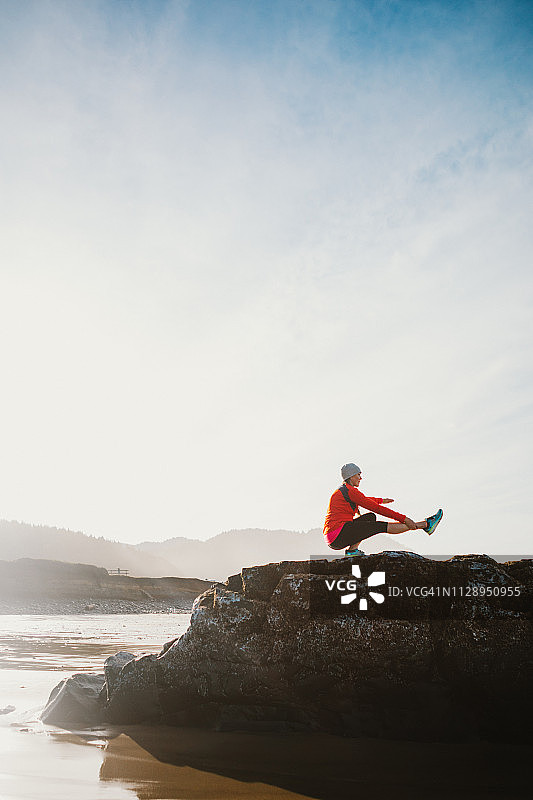 在海滩上做瑜伽的中年妇女图片素材