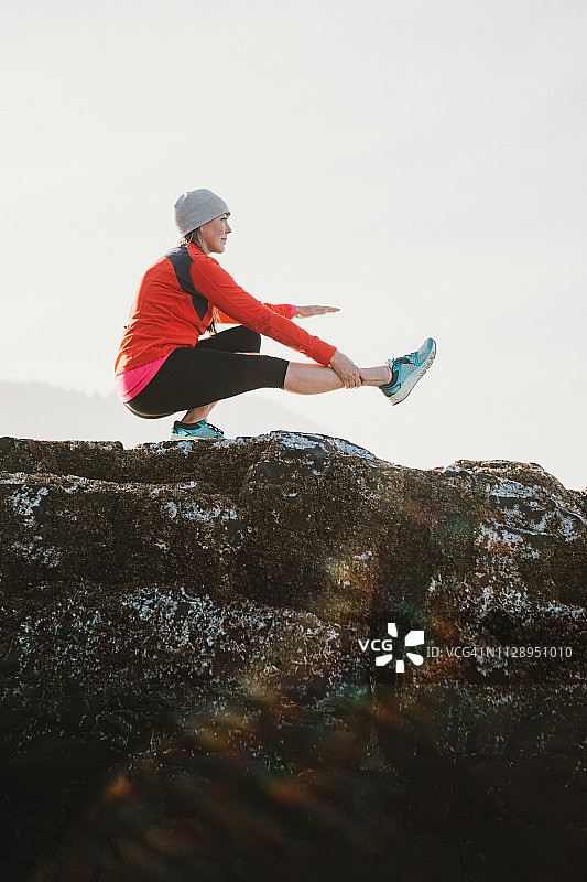 在海滩上做瑜伽的中年妇女图片素材