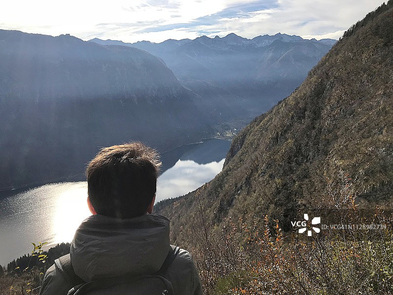 男孩在山顶欣赏湖景图片素材