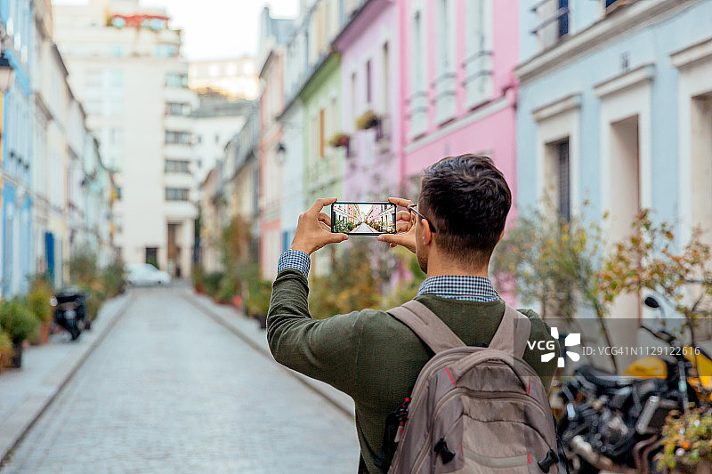 在巴黎街头用手机拍照的游客（背面视角）图片素材