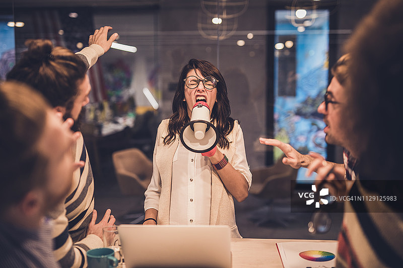 愤怒的女经理用扩音器训斥同事图片素材