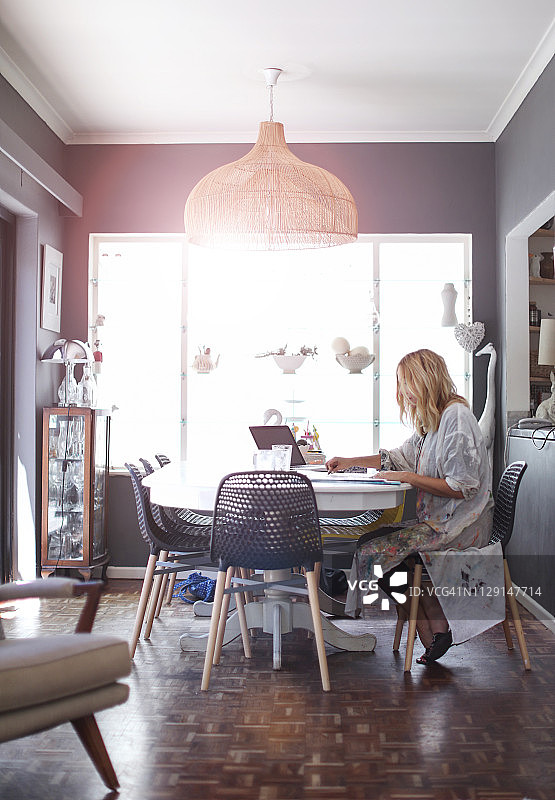 在家中餐桌上素描的中年妇女图片素材