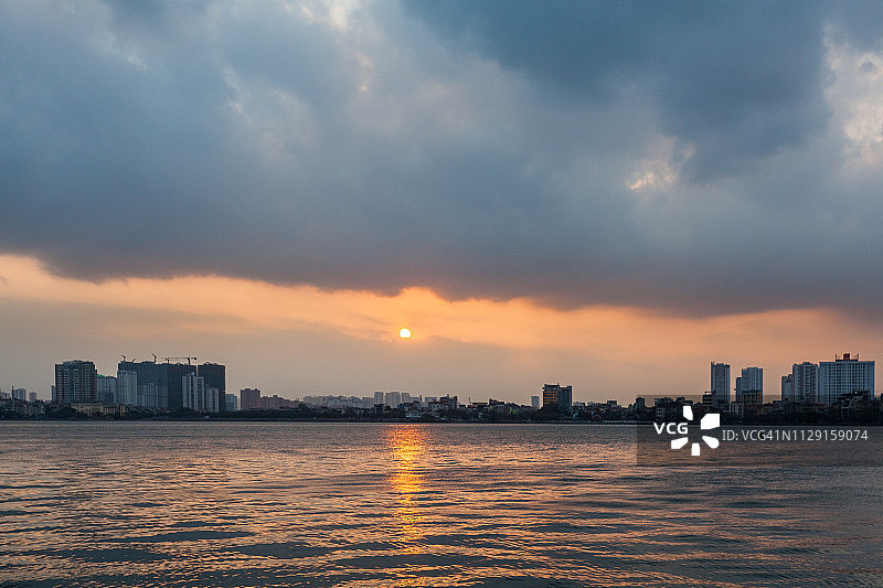 越南河内西湖的壮丽日落与城市建筑图片素材