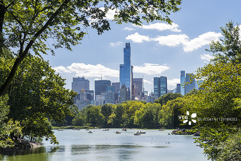 看不清脸的人们在纽约中央公园的湖上划船图片素材