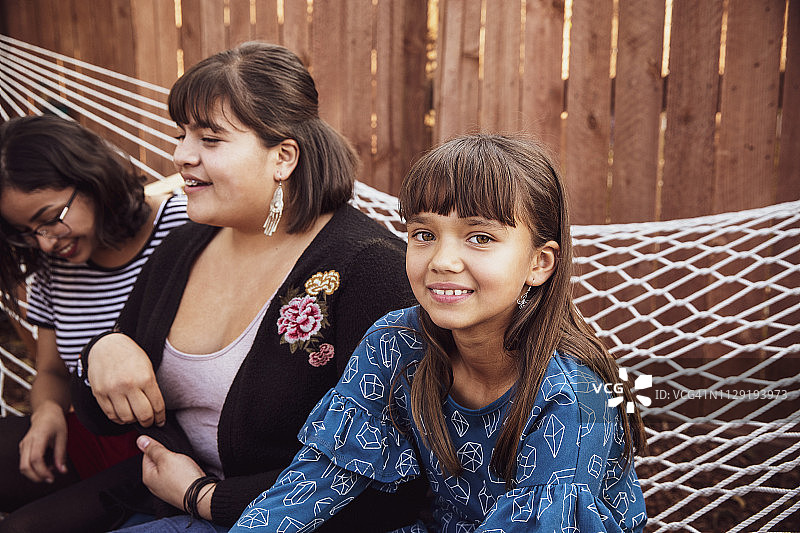 坐在吊床上享受家庭聚会的堂/表兄弟姐妹图片素材