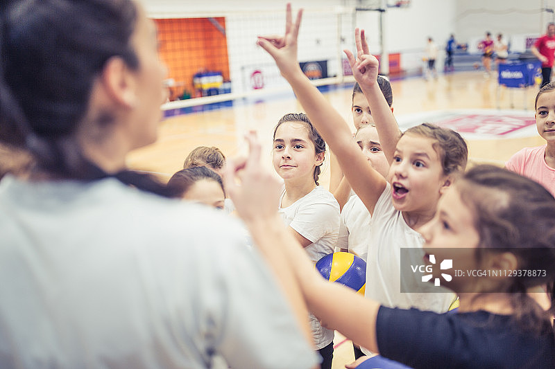 女教练在排球场上与女孩们交谈图片素材