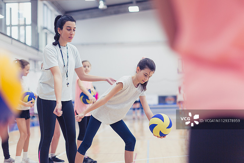 女教练在排球场上与女孩们交谈图片素材