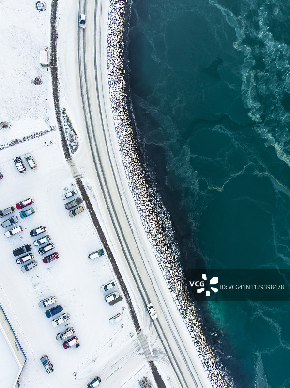 空中视角 - 冰岛冬季的停车场、道路和水域图片素材