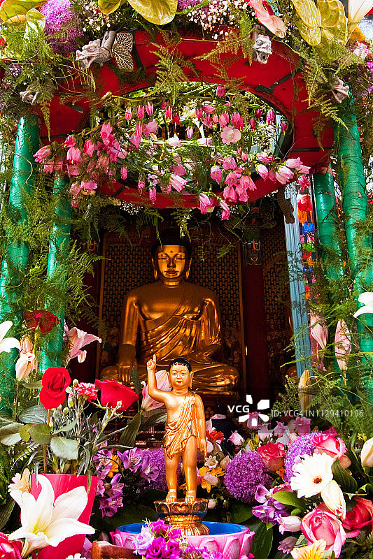 鲜花装饰的佛像与小佛像图片素材