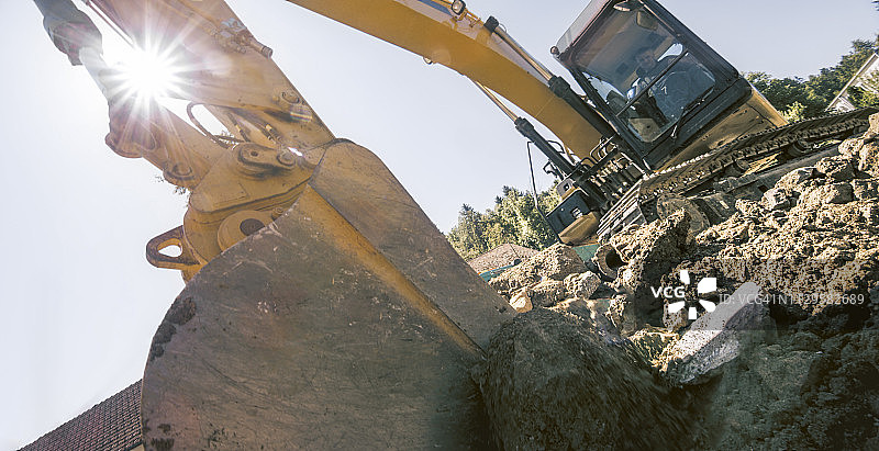 挖掘机在建筑工地抓取泥土和碎片图片素材