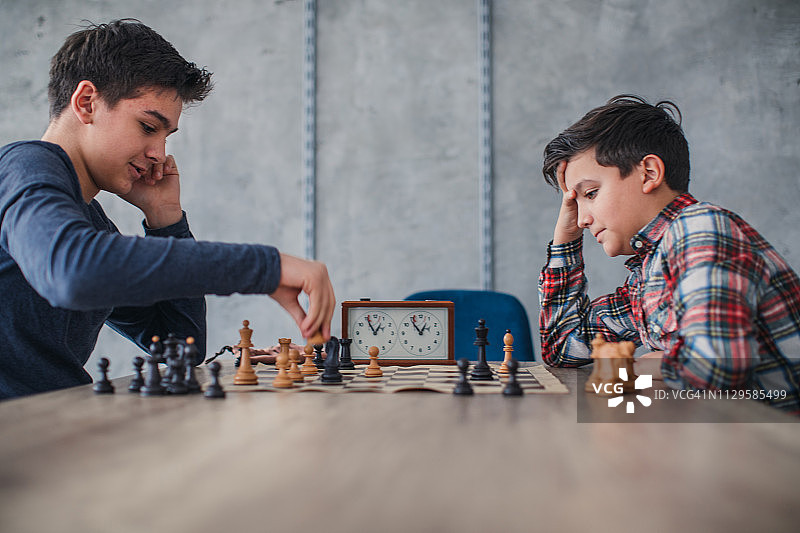 在国际象棋学校里下棋的聪明的男孩图片素材