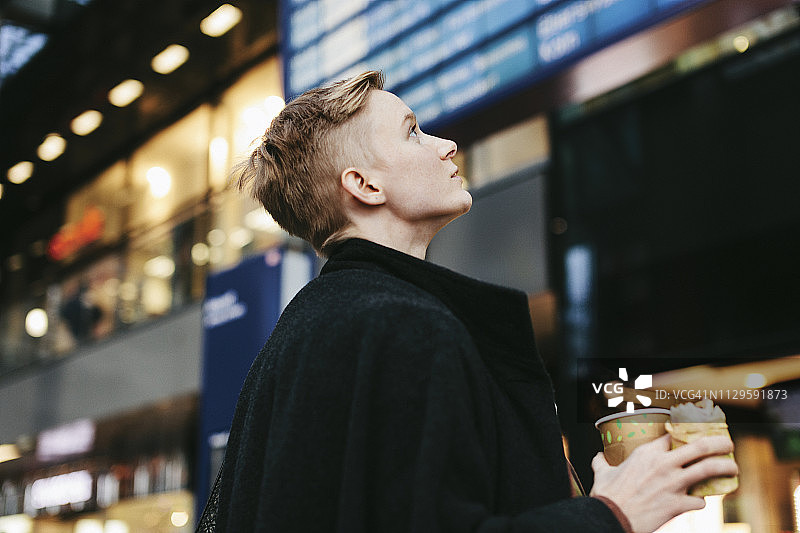 单亲妈妈拿着零食看列车时刻表图片素材