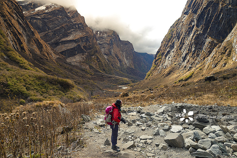 在尼泊尔壮丽山谷背景下的女徒步旅行者图片素材