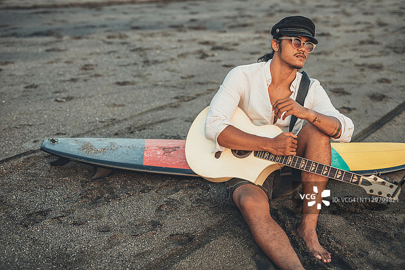 冲浪者在海滩弹吉他图片素材