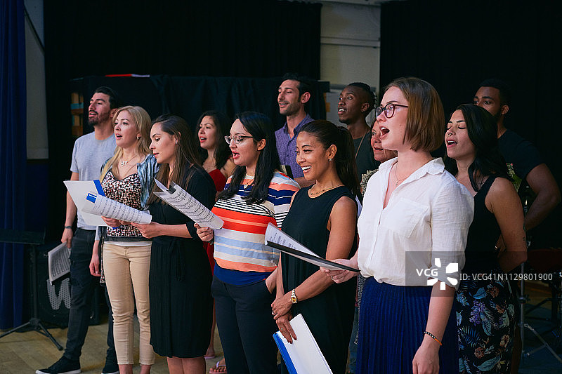 不同民族的男女学生在礼堂合唱图片素材