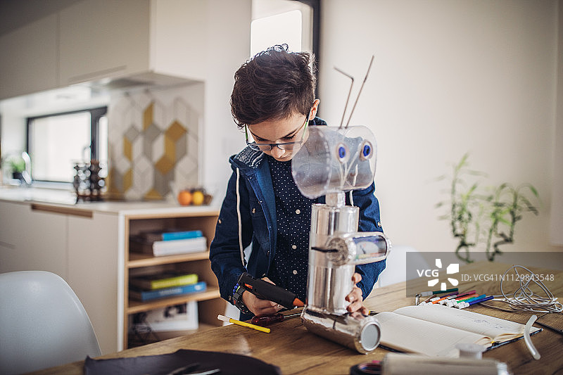 男孩工程师为学校科学项目组装机器人图片素材