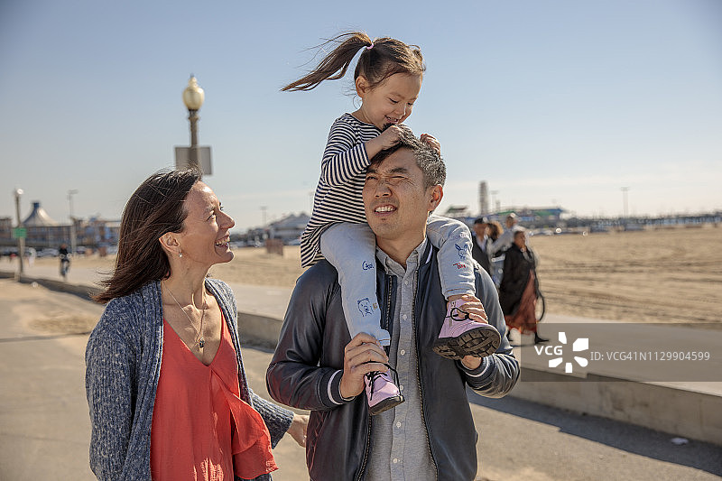 在圣莫尼卡冬季海滩野餐的多民族家庭图片素材